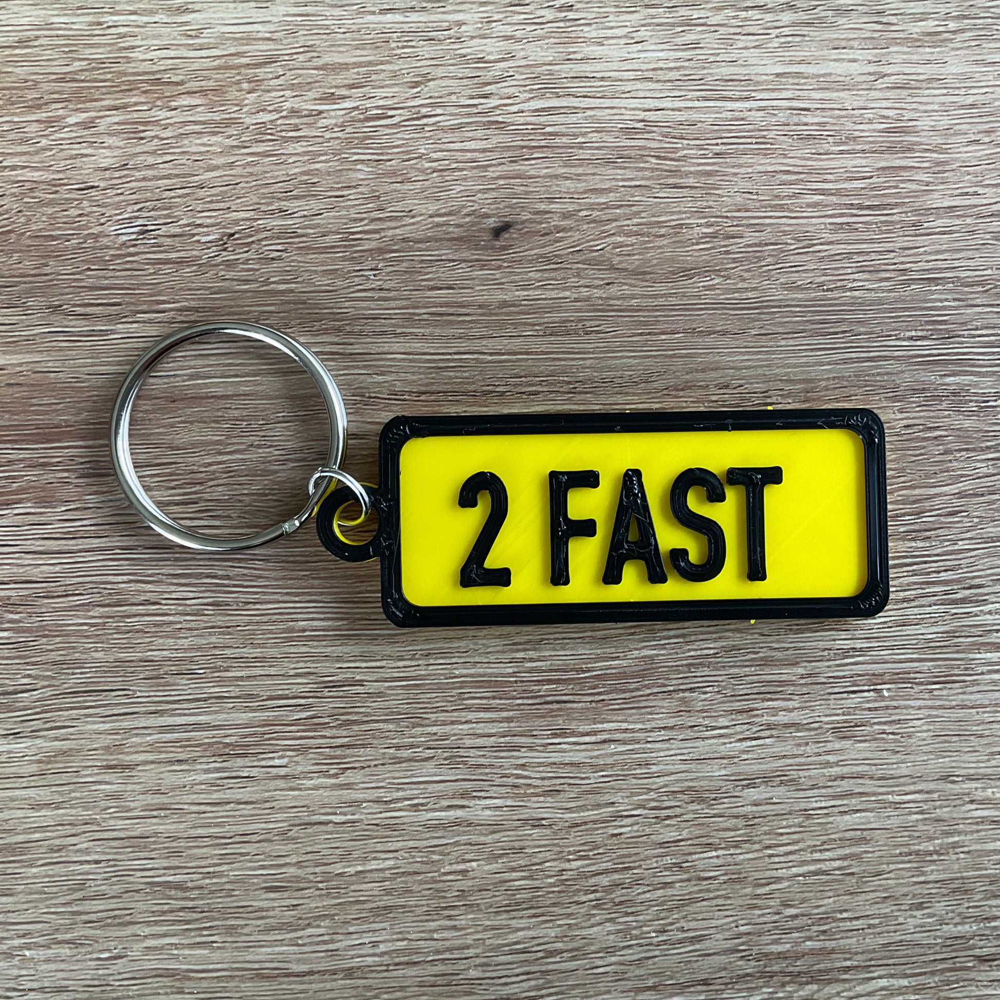 a picture of the too fast keychain in black and yellow.