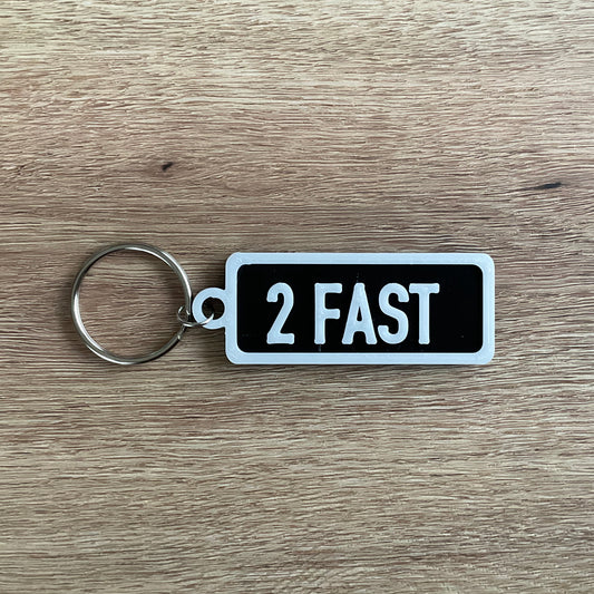 an image of the white on black version of the too fast numberplate keychain.