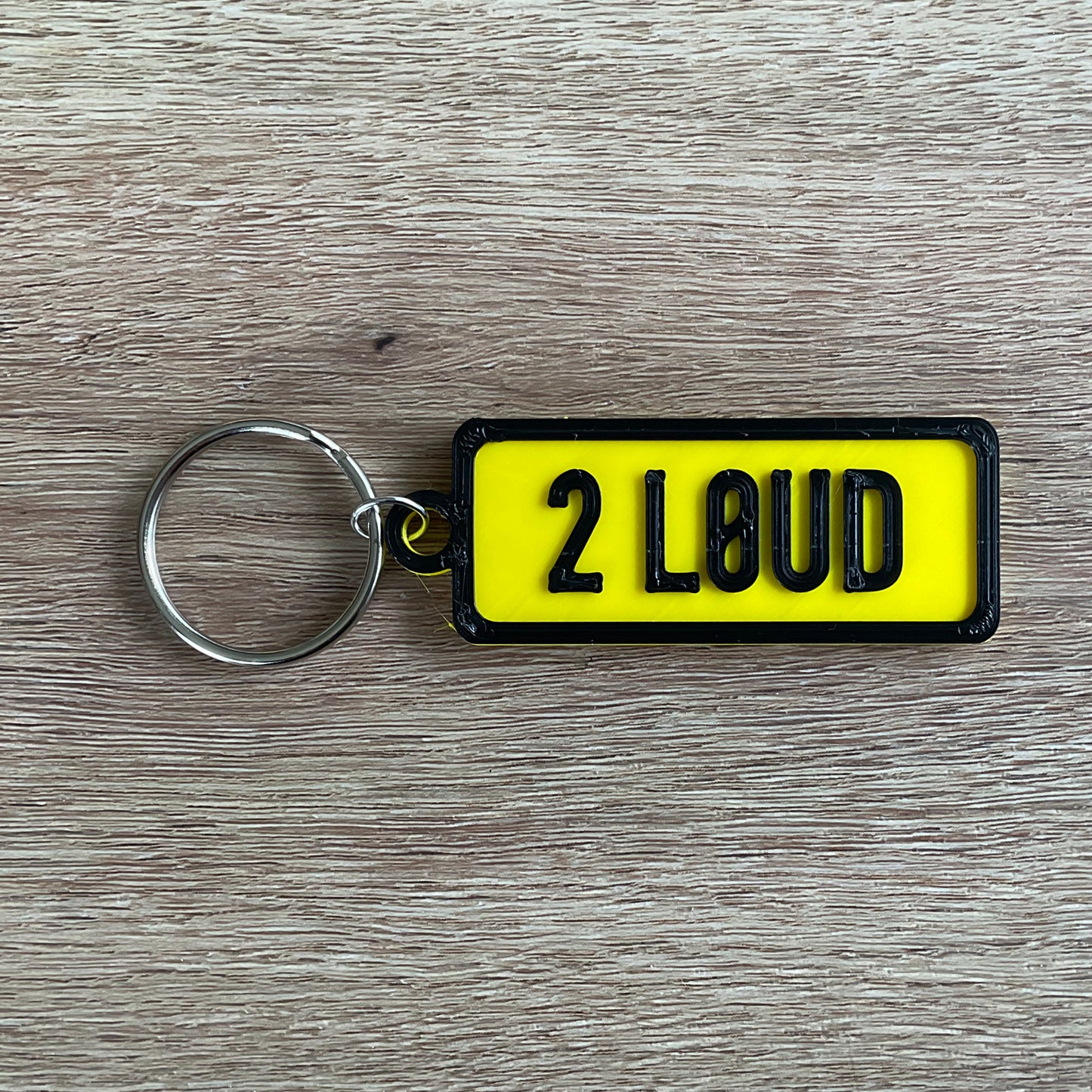 a picture of the too loud keychain in black and yellow.