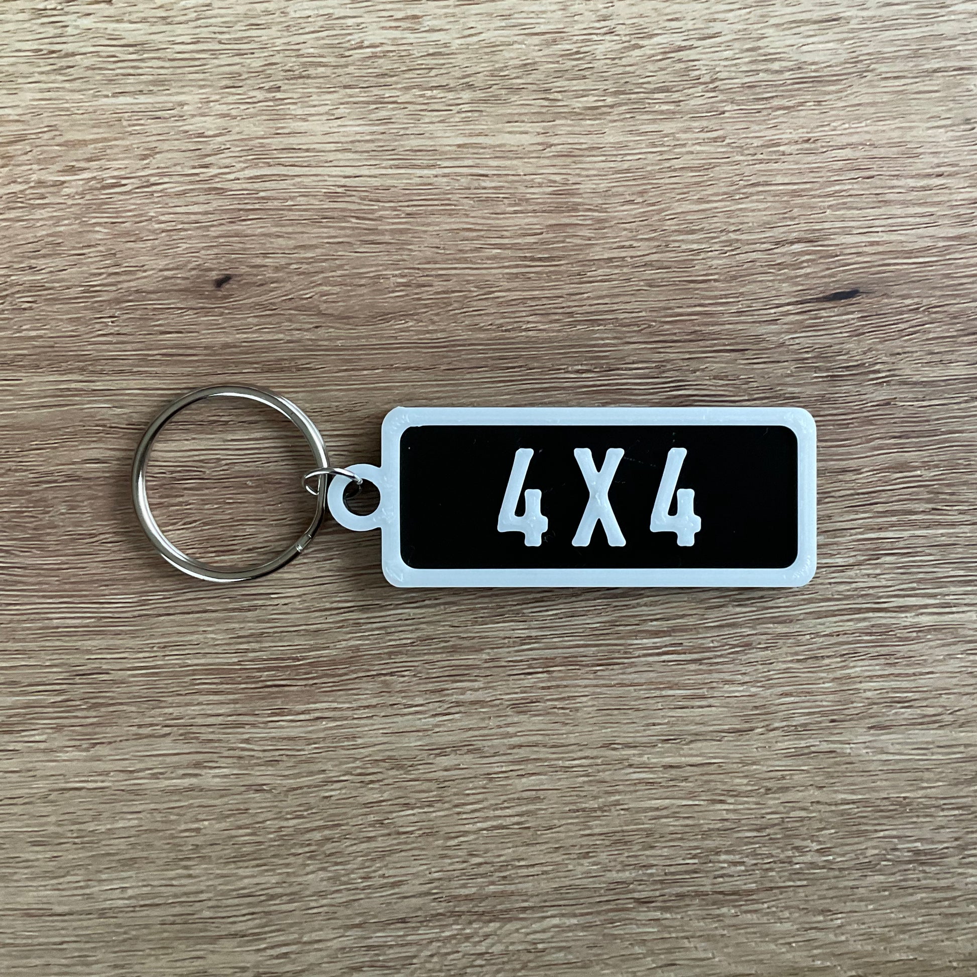 an picture of the white on black version of the four by four numberplate keychain.