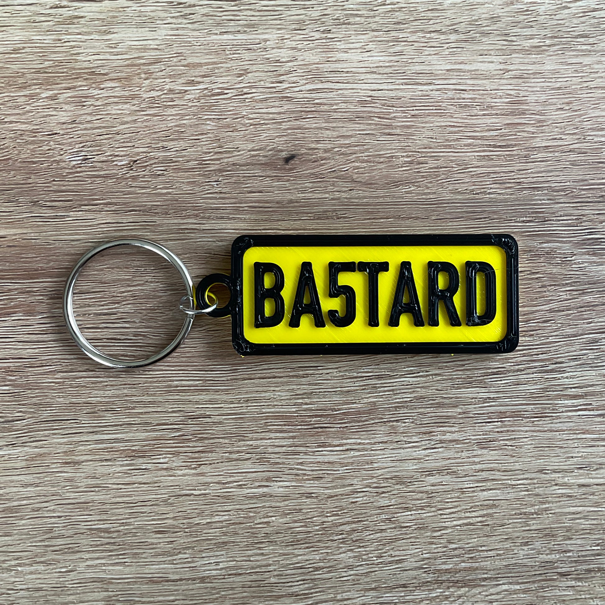 a picture of the bastard keychain in yellow