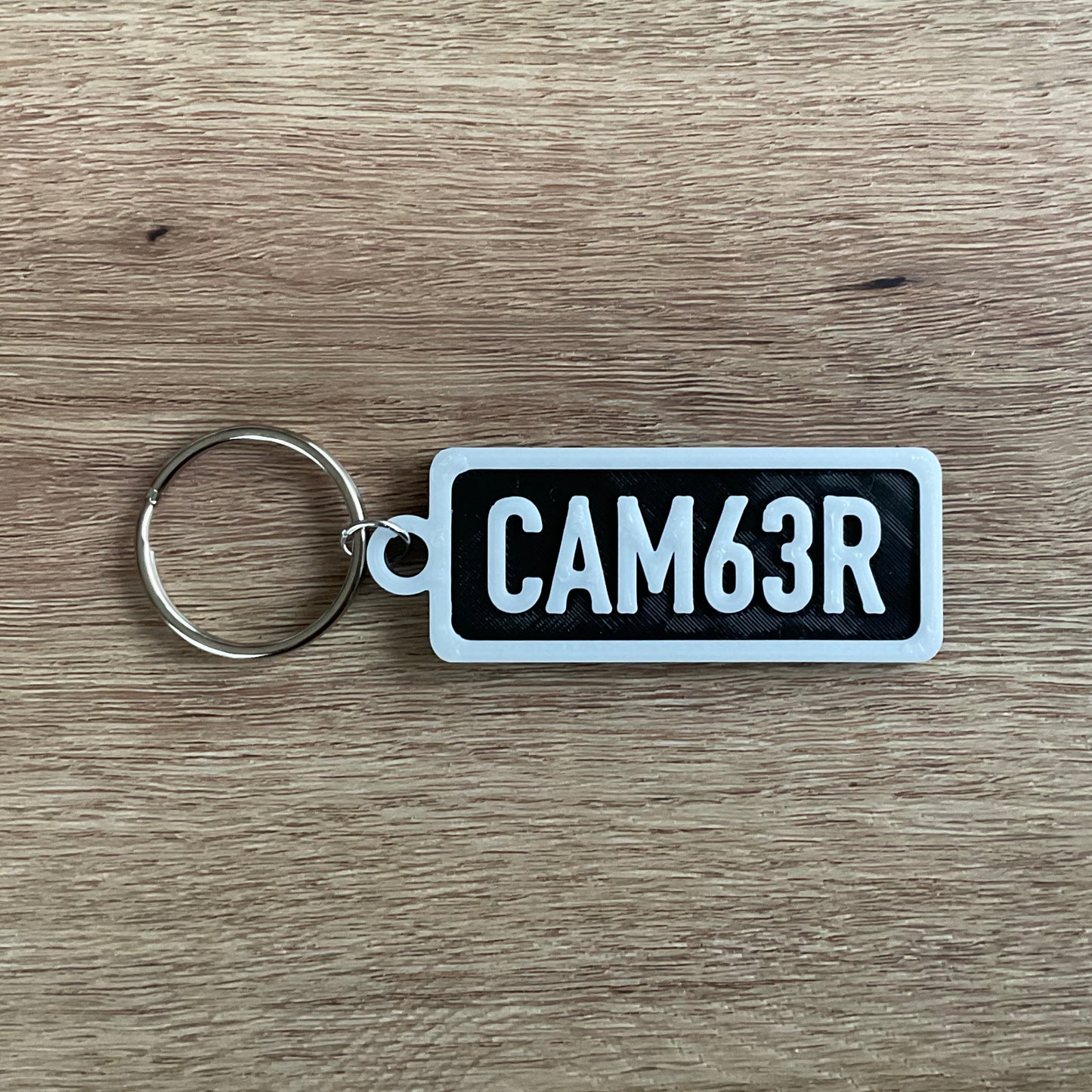 A picture of the white on black version of the camber numberplate keychain. 