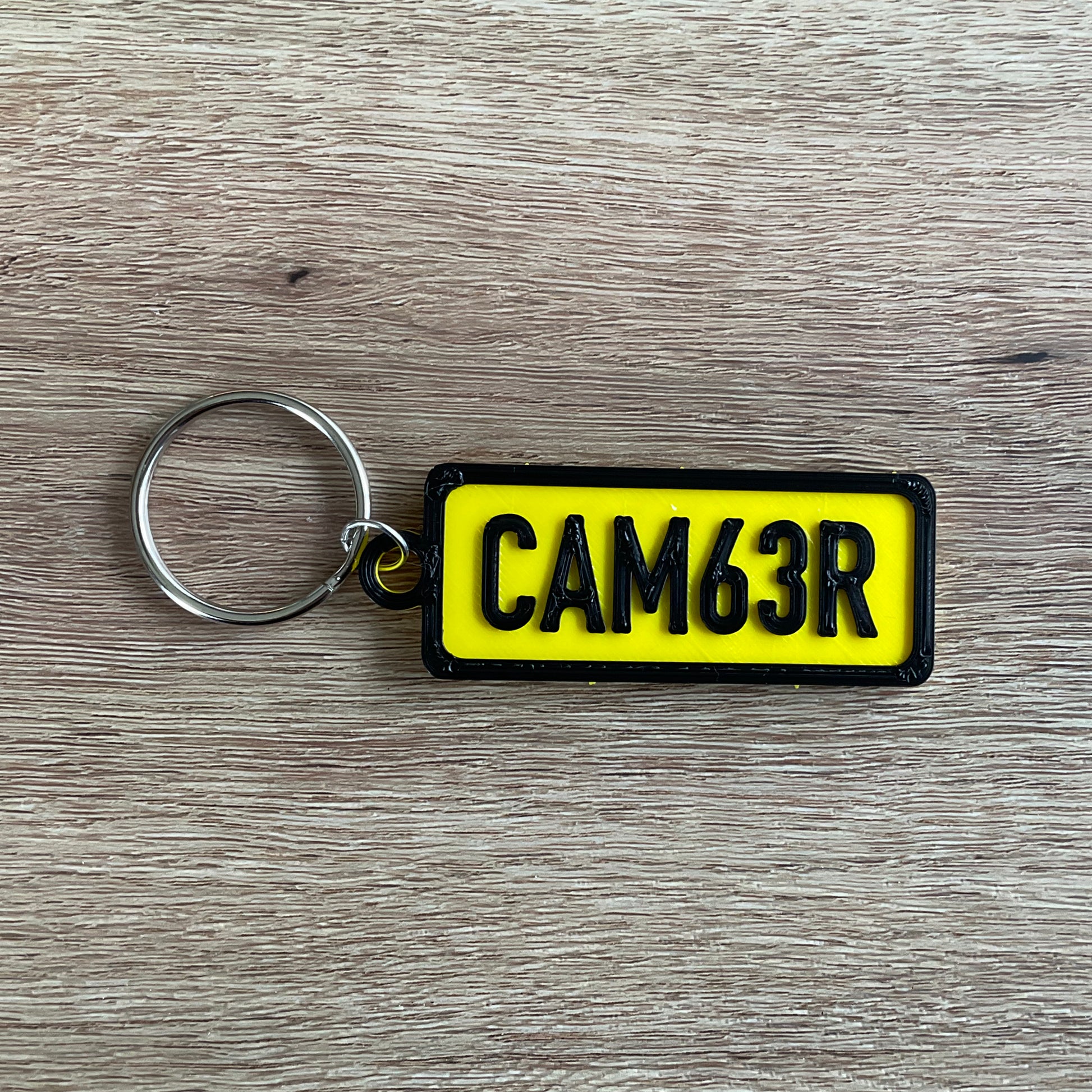 a picture of the camber numberplate keychain in black and yellow
