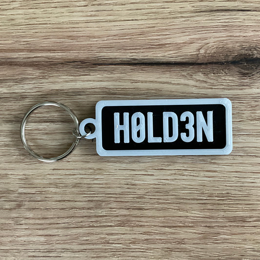 An image of the black Holden keychain in the colour black with white lettering and borders.