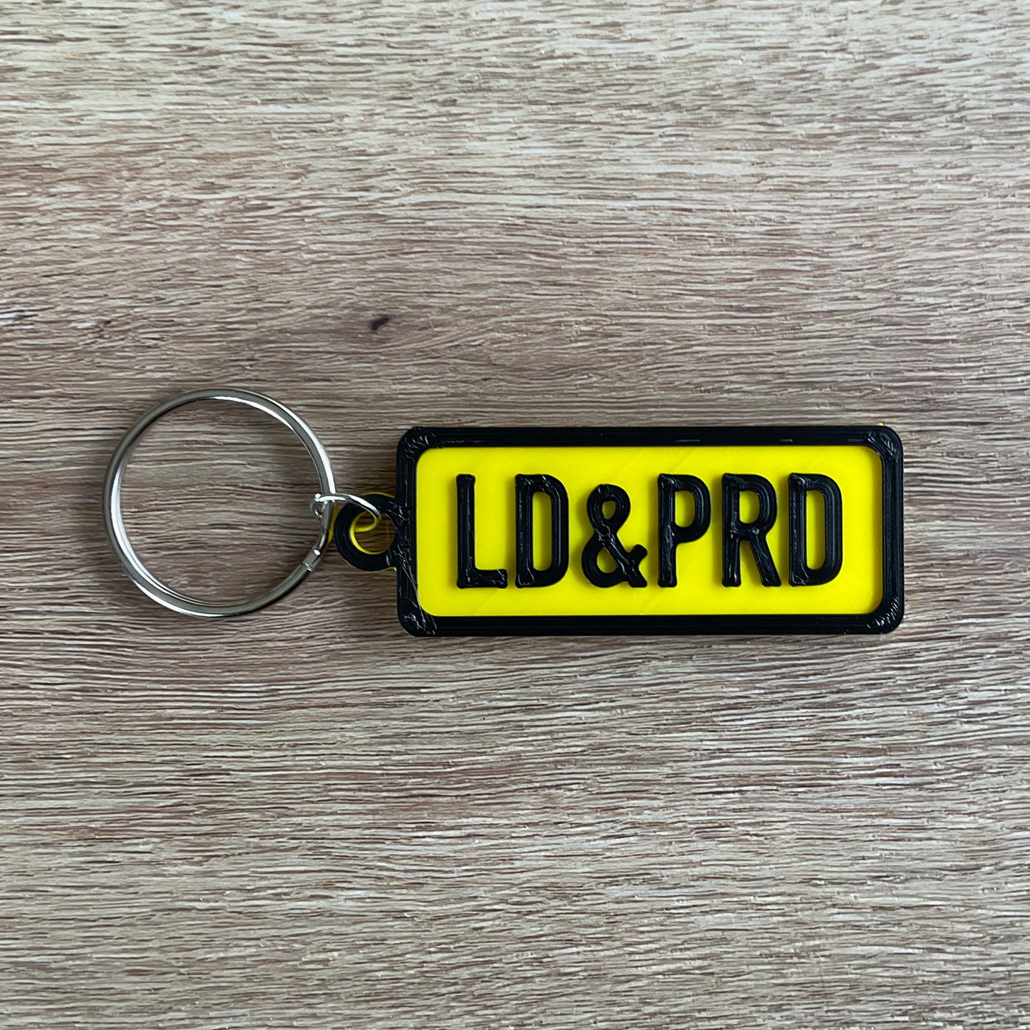 a picture of the black on yellow version of the loud and proud numberplate keychain.