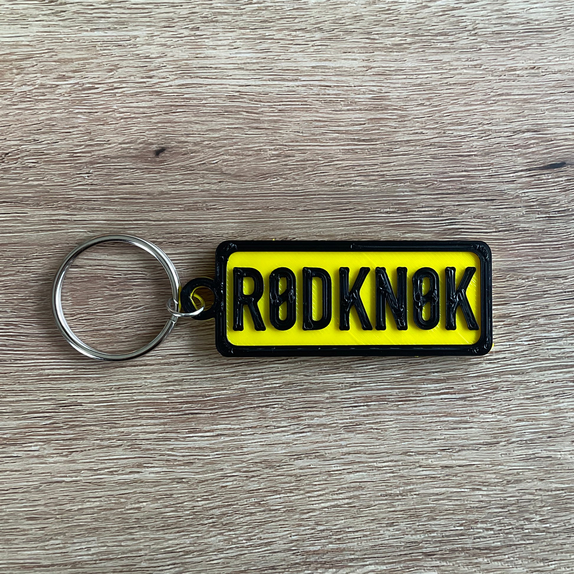 a picture of the black on yellow version of the rod knock numberplate keychain.