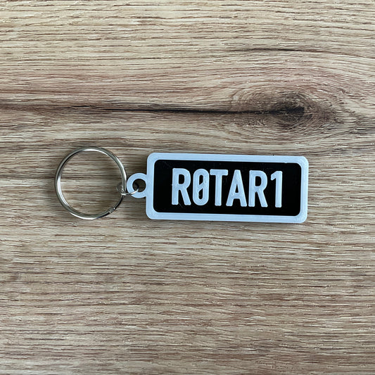 an image of the black rotary keychain with white border and lettering.