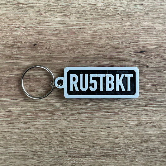 a picture of the white on black version of the rust bucket keychain.