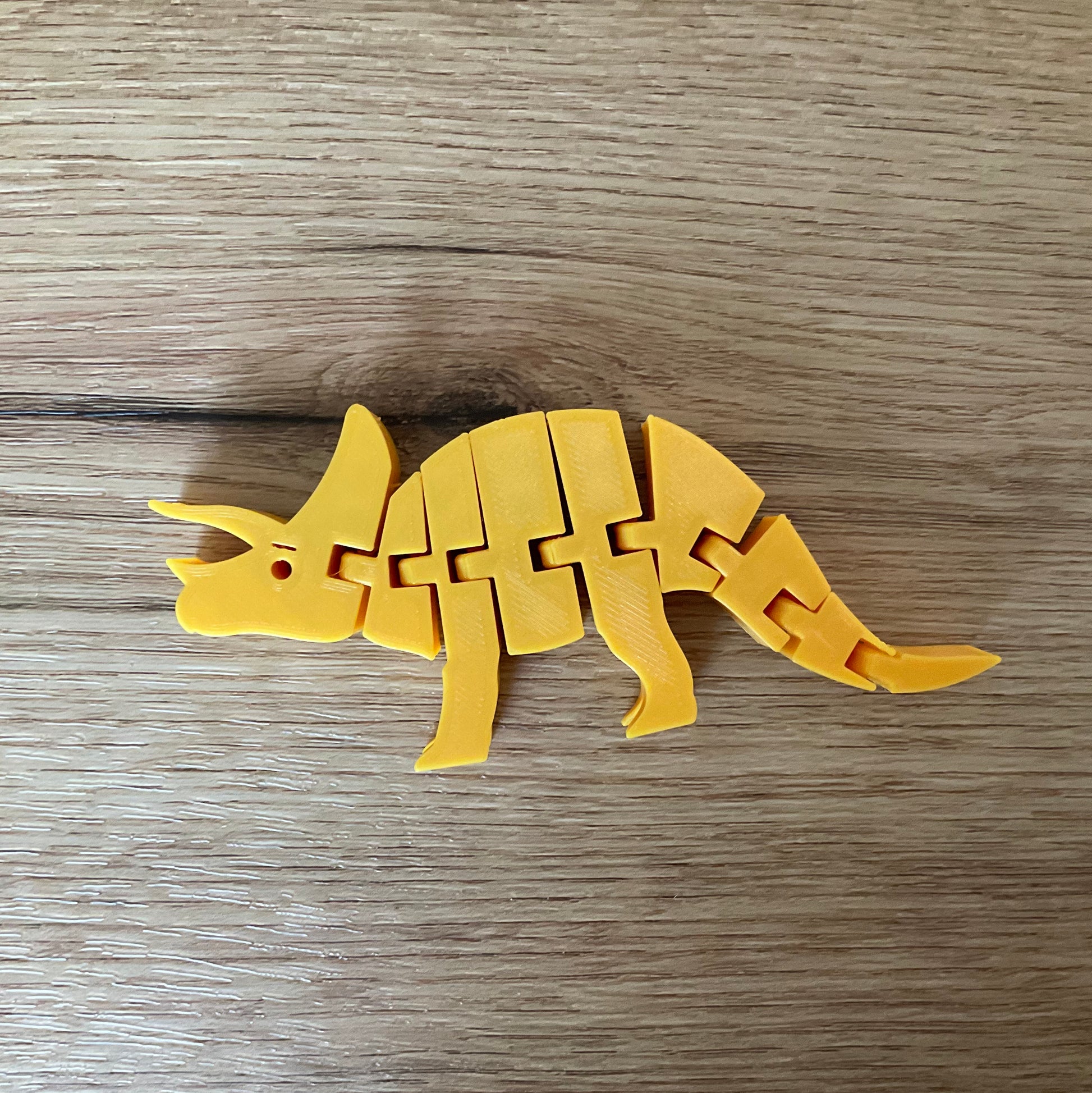 a Picture of the triceratops articulated toy in gold.