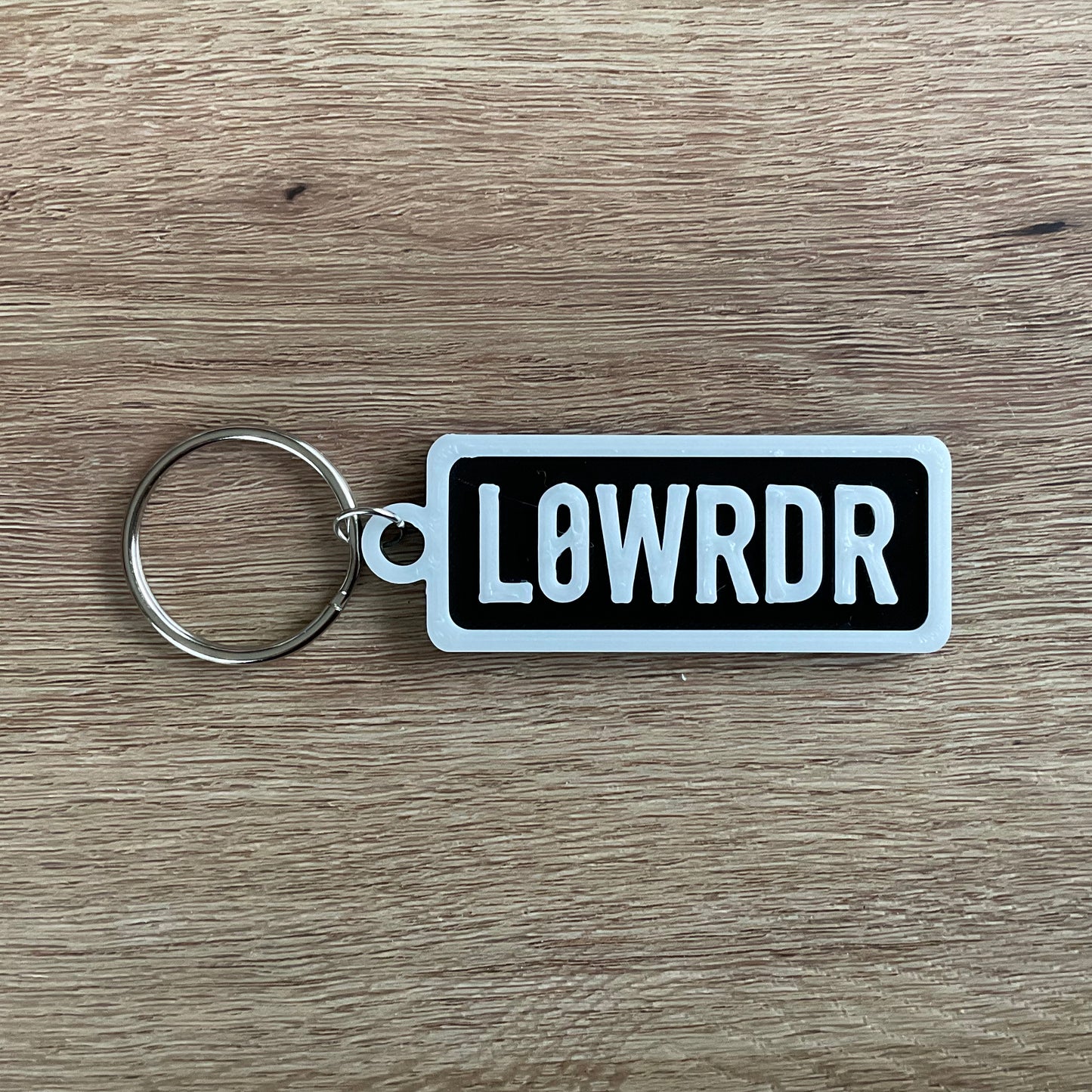 a picture of the white on black version of the low rider numberplate keyring